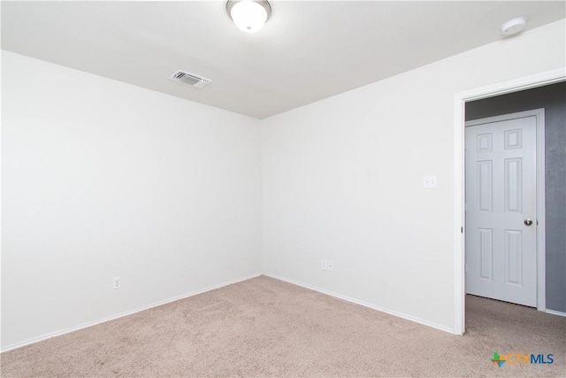 spare room featuring baseboards, visible vents, and carpet floors