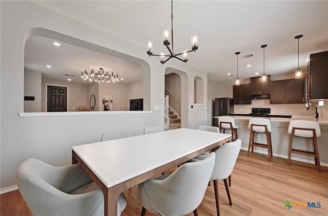 6309 Carriage Pines Dr, Del Valle, TX 78617 - dining room featuring recessed lighting, arched walkways, light wood finished floors, visible vents, and a notable chandelier