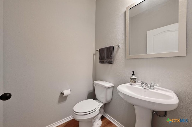 6309 Carriage Pines Dr, Del Valle, TX 78617 - bathroom featuring baseboards, wood finished floors, and toilet