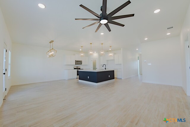 unfurnished living room with ceiling fan and light hardwood / wood-style flooring