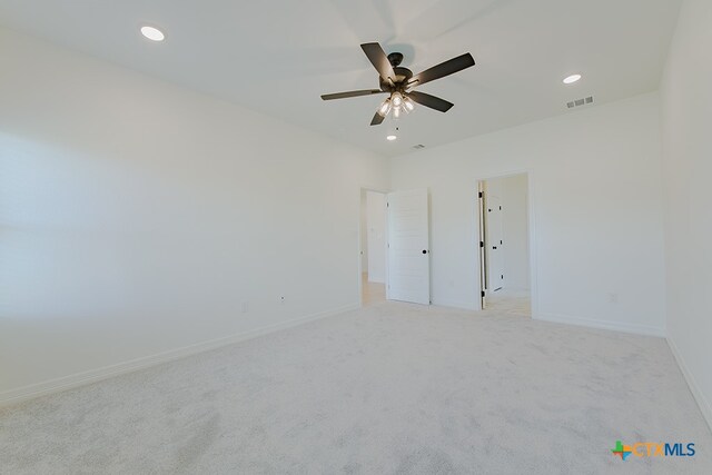 carpeted spare room featuring ceiling fan