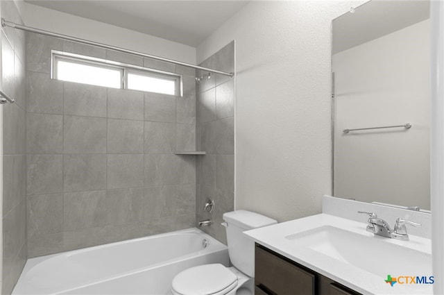 full bathroom with vanity, tiled shower / bath combo, and toilet