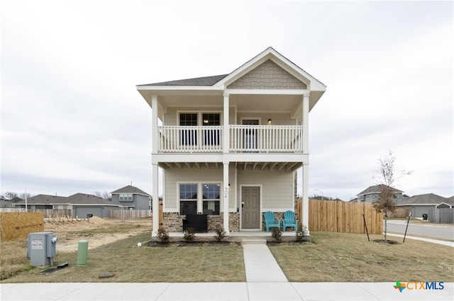 view of front of property with a balcony and a front yard