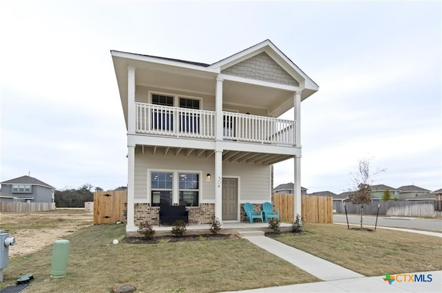 view of front of house with a balcony and a front lawn