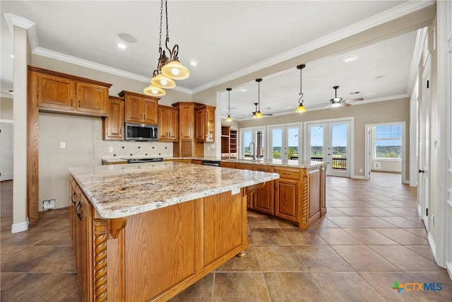 34 Spruce Dr, Belton, TX 76513 - kitchen with stainless steel microwave, ceiling fan, a peninsula, brown cabinets, and backsplash