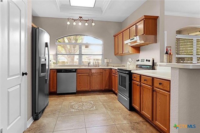 kitchen with light countertops, appliances with stainless steel finishes, ornamental molding, a sink, and under cabinet range hood