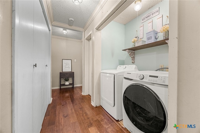 laundry room featuring washing machine and dryer, a textured ceiling, dark hardwood / wood-style flooring, and crown molding