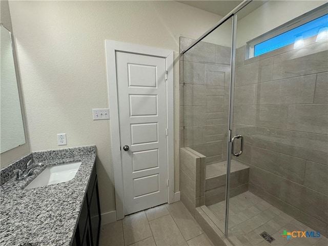 full bathroom with a stall shower, tile patterned flooring, and vanity