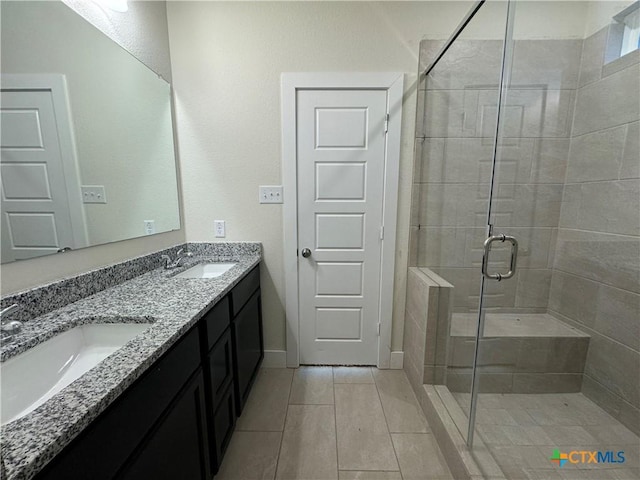 bathroom featuring double vanity, tile patterned floors, a sink, and a shower stall