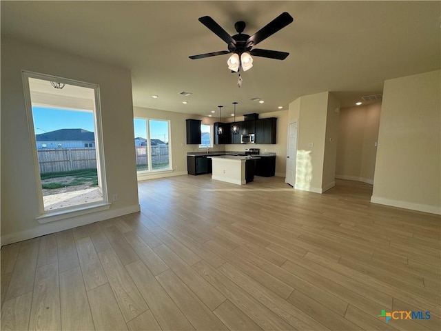 unfurnished living room with visible vents, baseboards, a ceiling fan, light wood-style floors, and recessed lighting