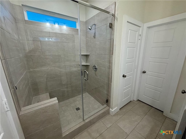 bathroom with a shower stall and tile patterned floors