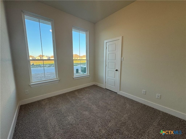 unfurnished room featuring carpet floors and baseboards