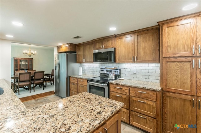 kitchen with stainless steel appliances, brown cabinets, and visible vents