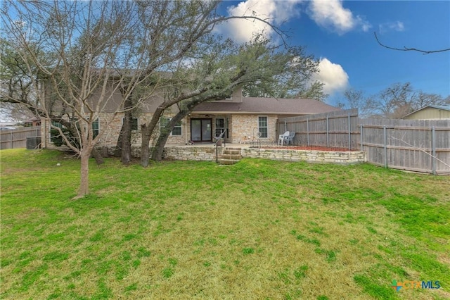 back of property with a yard and a fenced backyard