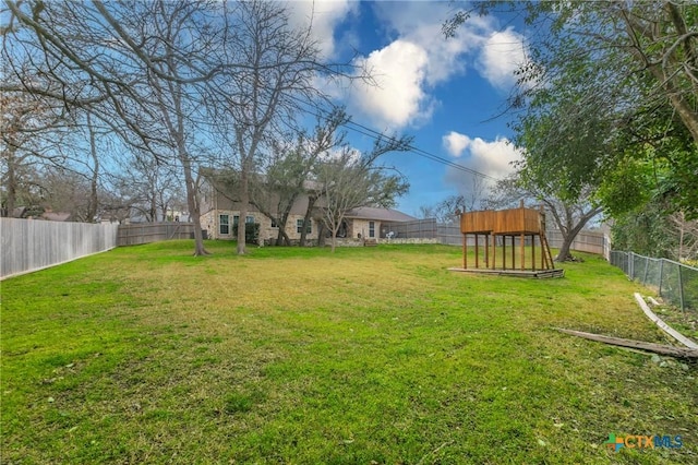 view of yard with a playground and a fenced backyard