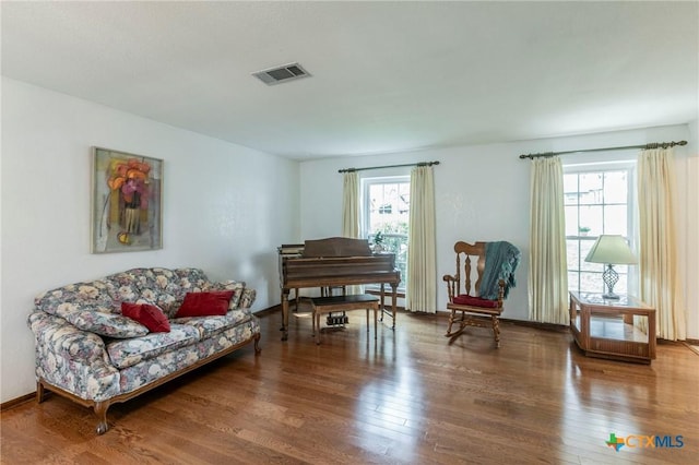 sitting room featuring a wealth of natural light, baseboards, visible vents, and wood finished floors