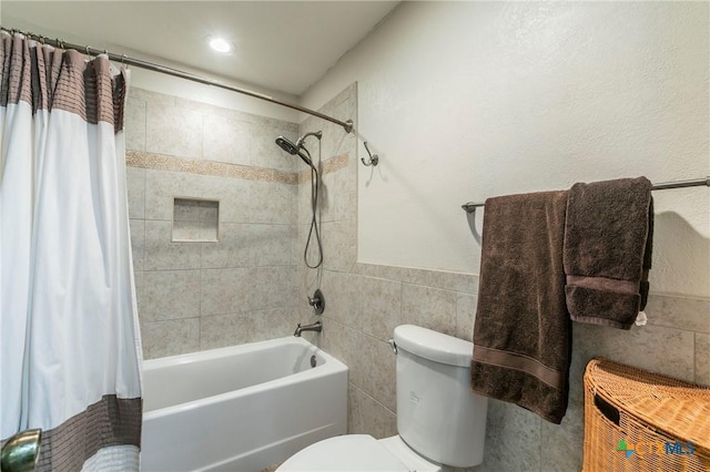 full bath with toilet, shower / tub combo, and tile walls