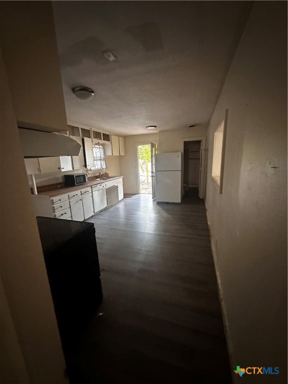 kitchen featuring white cabinetry, sink, dark hardwood / wood-style floors, and white appliances