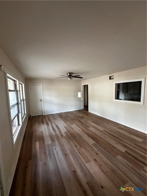 unfurnished living room featuring ceiling fan and hardwood / wood-style floors