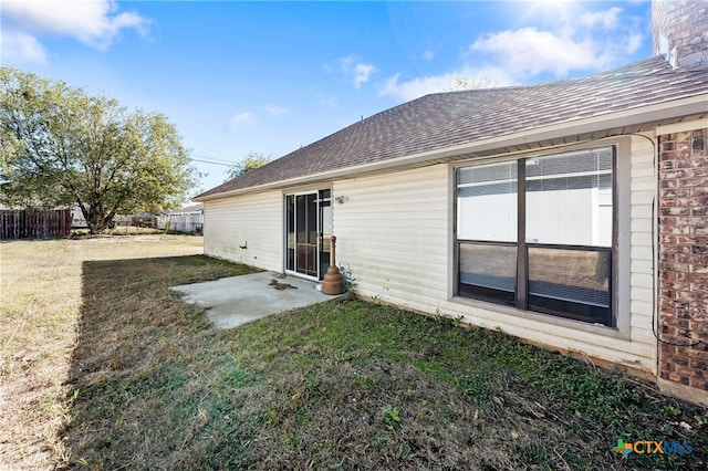 back of property with a lawn and a patio