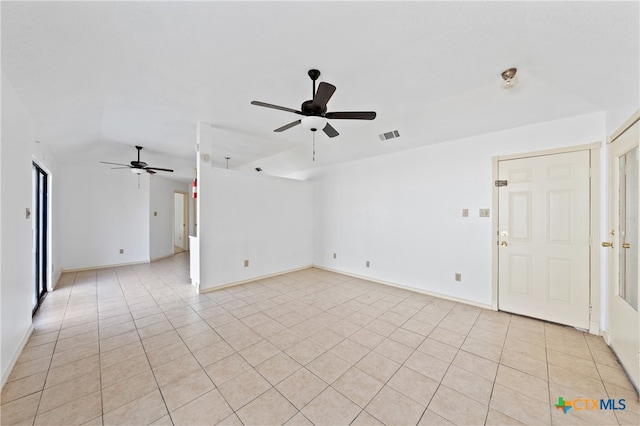 spare room with ceiling fan, light tile patterned flooring, and vaulted ceiling