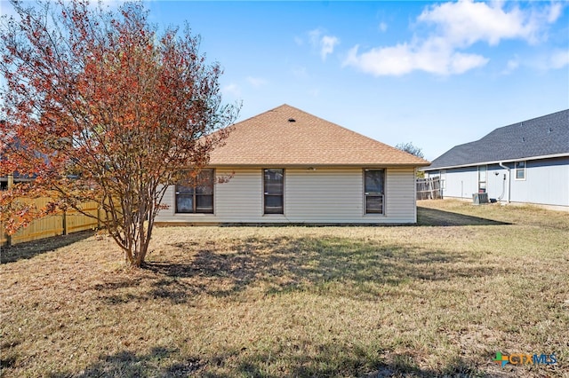 back of property with a lawn and central AC unit