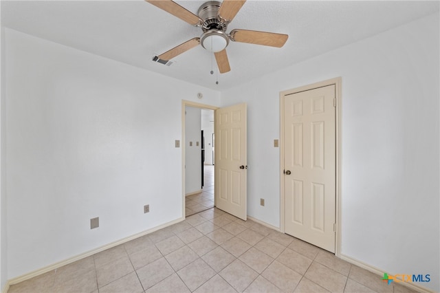 spare room with ceiling fan and light tile patterned flooring