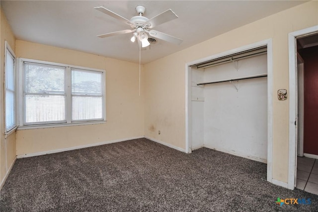 unfurnished bedroom featuring dark carpet, a closet, and ceiling fan