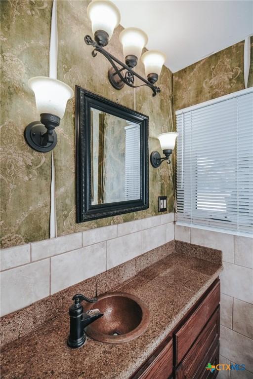 bathroom featuring vanity and tasteful backsplash