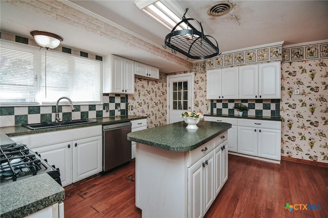 kitchen featuring dark wood-type flooring, white cabinets, stainless steel dishwasher, and sink