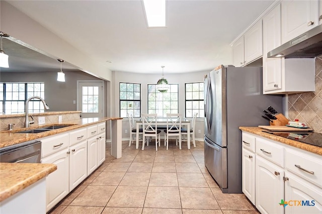1104 Southridge, Salado, TX 76571 - kitchen with a sink, under cabinet range hood, backsplash, white cabinets, and pendant lighting
