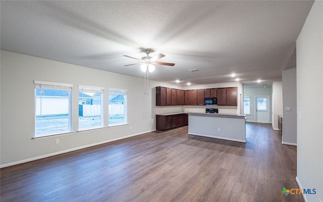 kitchen with a center island, black appliances, a textured ceiling, dark hardwood / wood-style floors, and ceiling fan