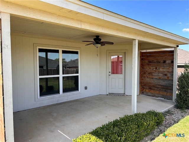 view of exterior entry featuring ceiling fan and a patio area