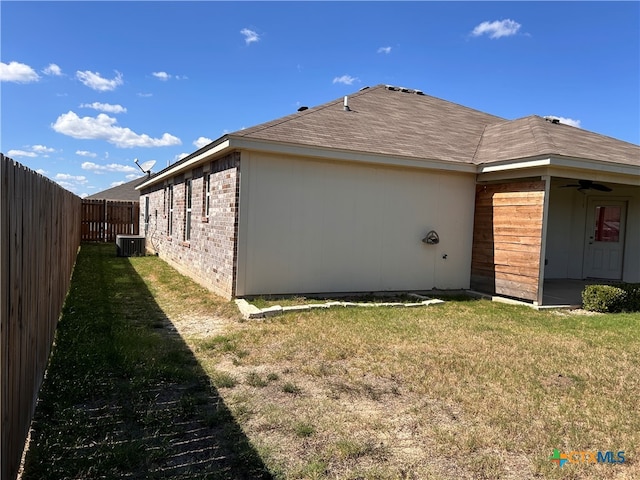 view of home's exterior featuring central air condition unit, a lawn, and ceiling fan