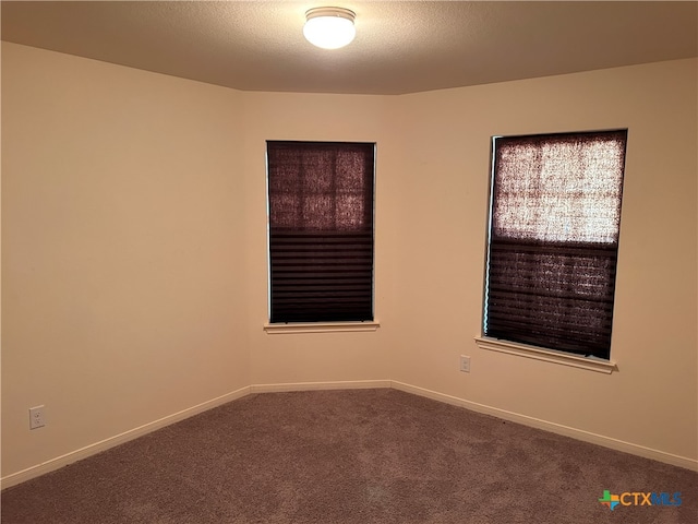 carpeted empty room with a textured ceiling