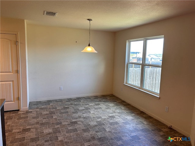 unfurnished dining area with a textured ceiling