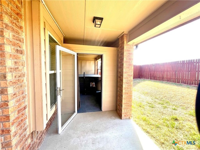 property entrance with brick siding and fence