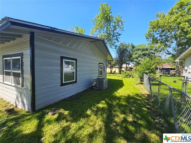 view of property exterior with a lawn and cooling unit