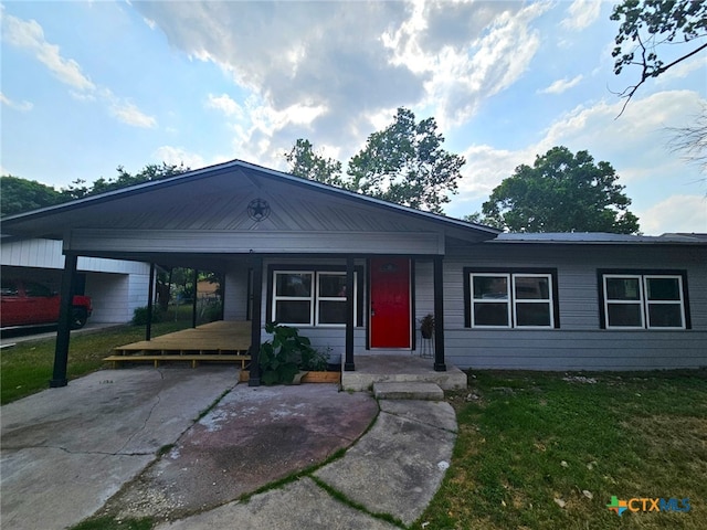 ranch-style home featuring a front yard and a carport