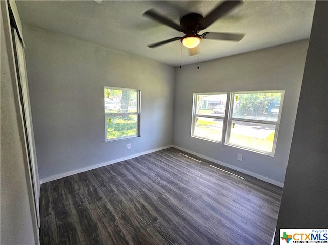 empty room featuring a textured ceiling, dark hardwood / wood-style floors, and ceiling fan