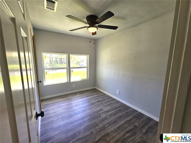 empty room featuring a textured ceiling, dark hardwood / wood-style floors, and ceiling fan