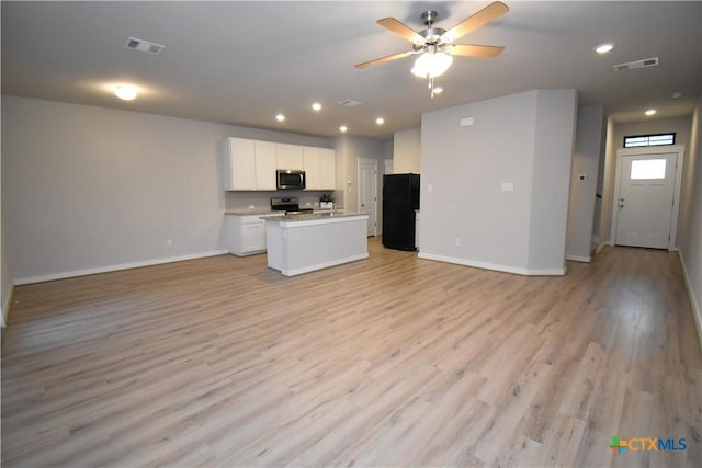 kitchen featuring light countertops, visible vents, appliances with stainless steel finishes, open floor plan, and white cabinets