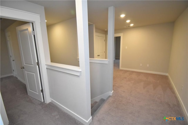 hallway with recessed lighting, baseboards, light carpet, and an upstairs landing