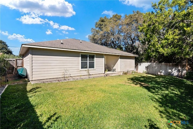 rear view of property with a lawn and a fenced backyard