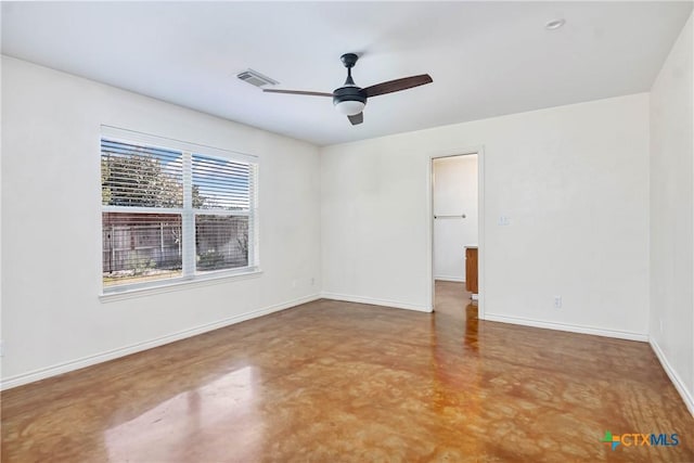 spare room featuring visible vents, baseboards, finished concrete flooring, and a ceiling fan