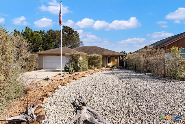 ranch-style house featuring driveway, an attached garage, and fence