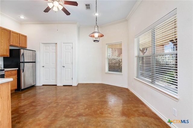 kitchen featuring decorative light fixtures, baseboards, concrete flooring, and freestanding refrigerator