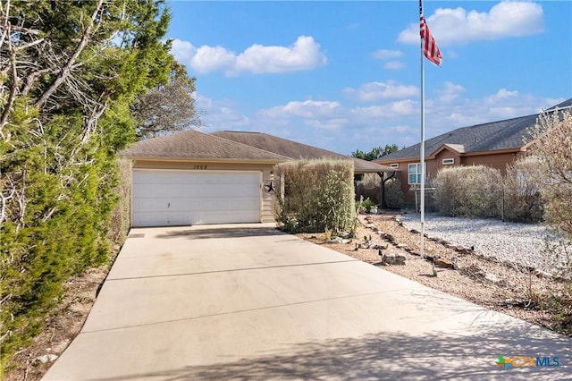 ranch-style home featuring an attached garage and driveway