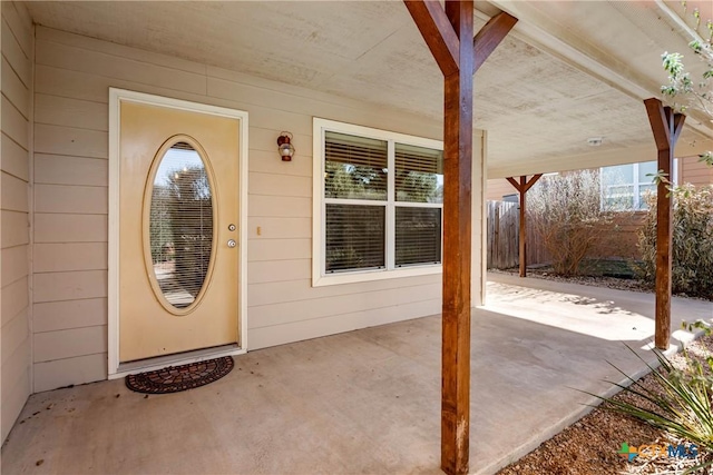 property entrance featuring a patio and fence