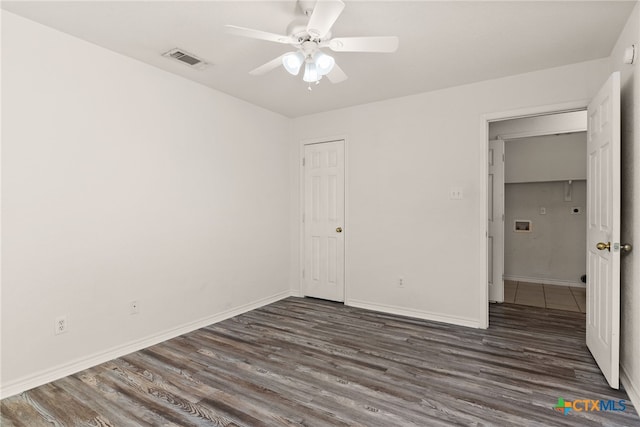 unfurnished bedroom with a closet, ceiling fan, and dark wood-type flooring